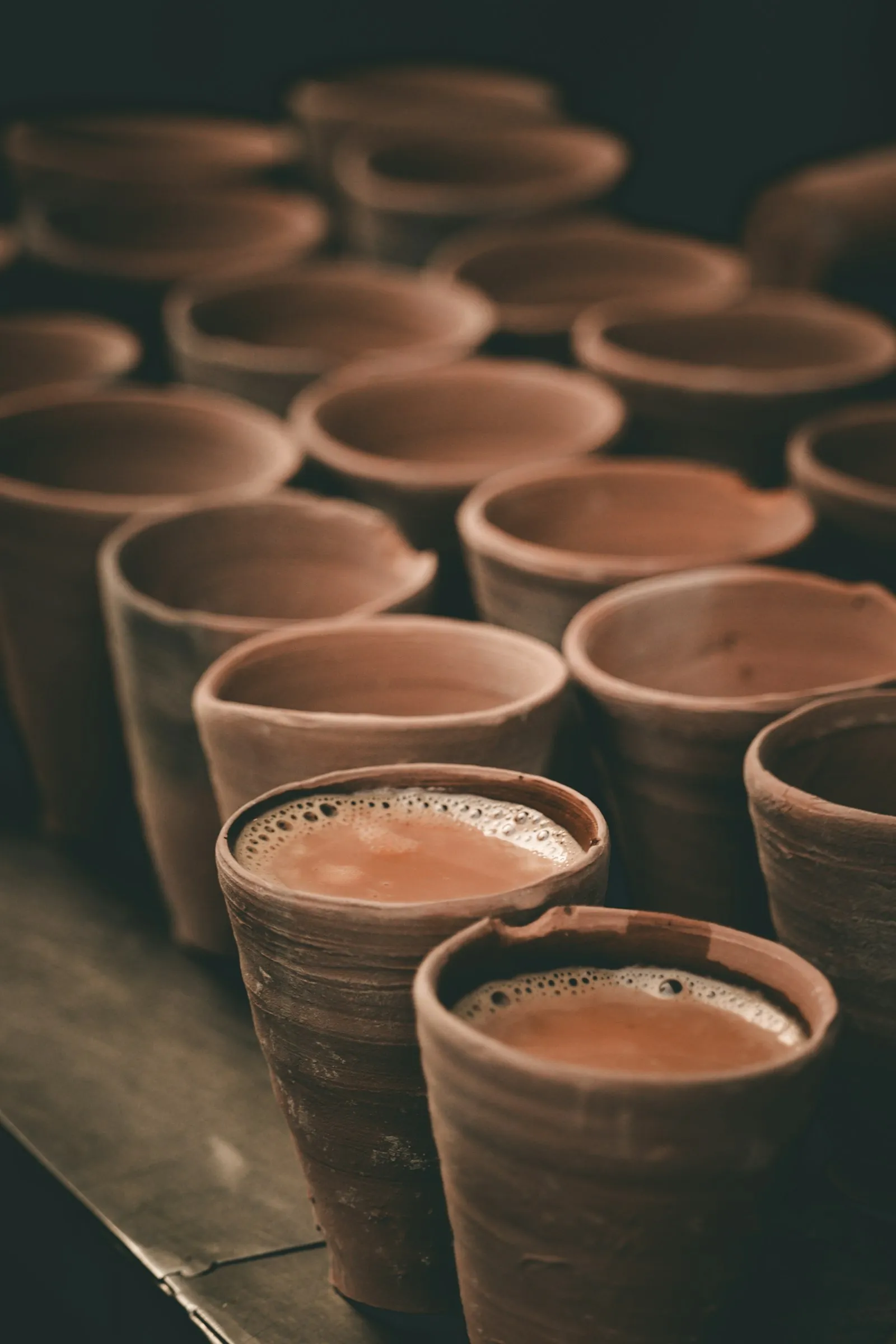 Rows of clay kulhads filled with tea